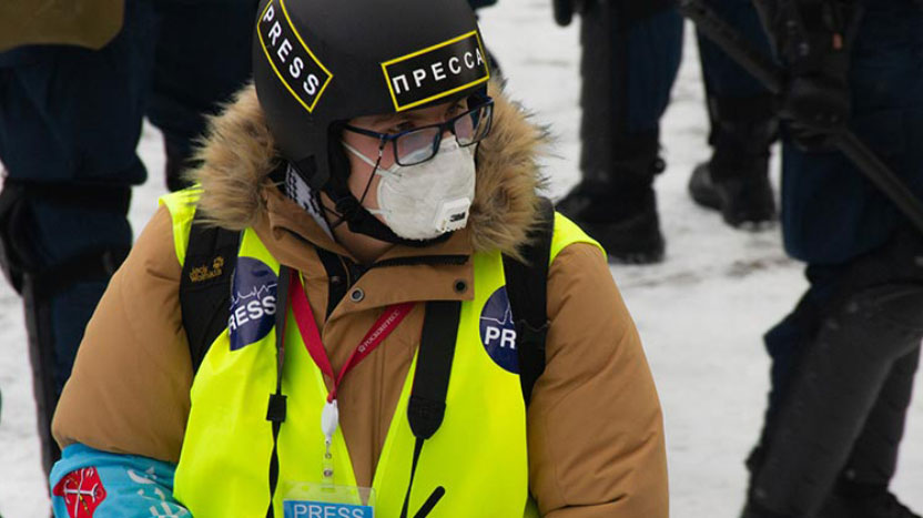Journaliste casqué et masqué