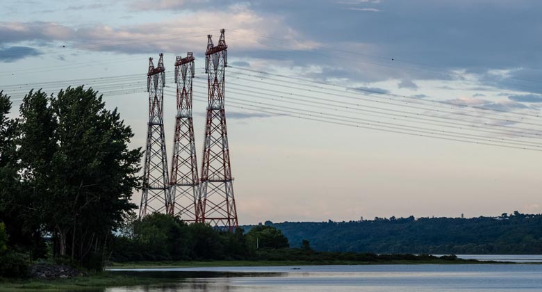 Electric pylons at the edge of a water body